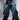 Baggy denim jeans featuring a relaxed fit and faded finish, styled with a fitted black tank top and unique chunky footwear.